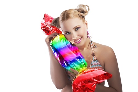 beautiful young woman with blond hair and stylish in bikini swimsuit with rainbow candyの写真素材