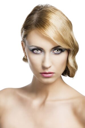 blond beautiful woman with strong make up and an old fashion hair stylish in beauty portrait close up, she is in front of the camera and looks in to the lensの写真素材