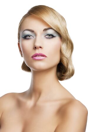 blond beautiful woman with strong make up and an old fashion hair stylish in beauty portrait close up. She is in front of the camera and looks in to the lens with mouth slightly open.の写真素材