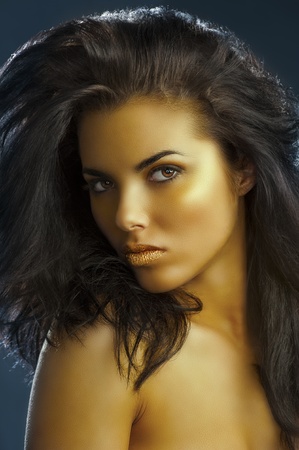 very cute girl with long dark hair,golden make up and shining gold color lipsの写真素材