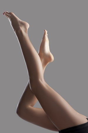 Long naked pretty woman legsin shorts  isolated with a fashion light の写真素材