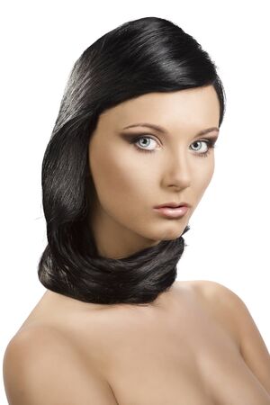 pretty brunete girl with long hair around the neck, she is turned of three quarters at left and looks in to the lensの写真素材