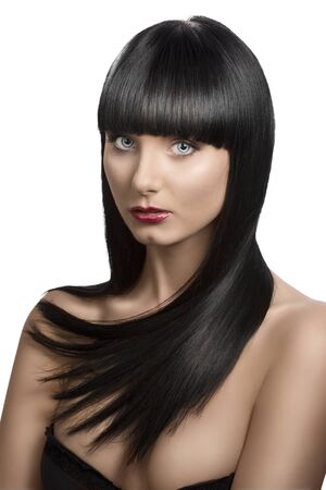 pretty girl with long, dark smooth hair and fringe, she is slightly turned of three quarters and looks in to the lensの写真素材