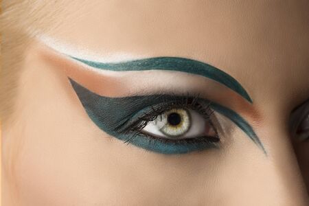 girl's eye closeup with creative green makeup. it's openの写真素材