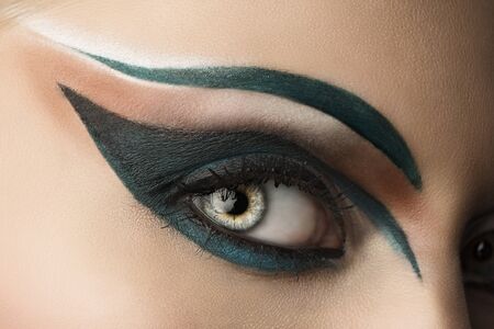 girl's eye closeup with creative green makeup, it looks at rightの写真素材