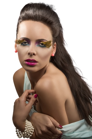 beautiful girl with long hair and feathered makeup, she looks in to the lens with sensual expression and her left shoulder is nakedの写真素材