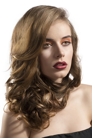 pretty girl with wavy hair and red lipstick, she is turned of three quarters at left and looks in front of herの写真素材