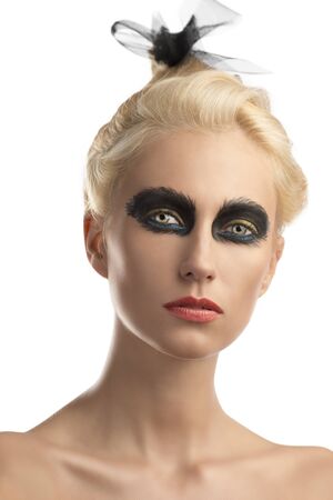 pretty blonde girl with creative dark make-up and upward hairstyle, she is in front of the camera and looks in to the lensの写真素材