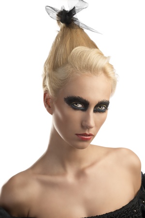 pretty blonde girl with creative dark make-up and upward hairstyle, she is turned of three quarters at left ans looks in to the lensの写真素材
