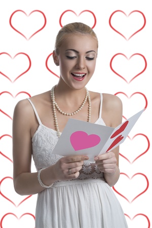 pretty blonde girl reads valentine postcard and takes that with both handsの写真素材