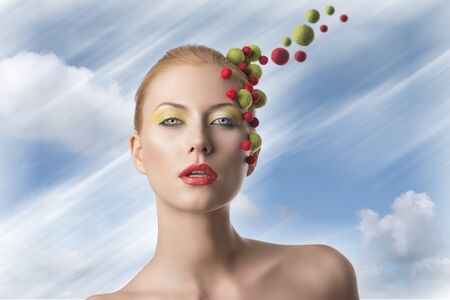very pretty blonde girl with different spheres color on the face doing a creative make upの写真素材