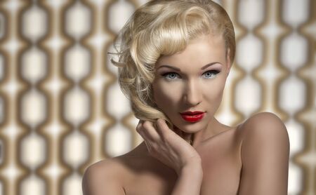 portrait of vintage woman with retro make-up and hair-style, looks in camera and posing as a diva on 70 backgroundの写真素材