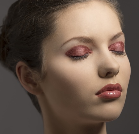 beauty close-up portrait of pretty young woman with brown hair and glossy red make-up and closed eyesの写真素材