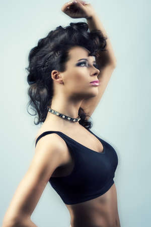 sexy brunette girl in fashion pose with creative hair-style and black top with motion blur effectの写真素材