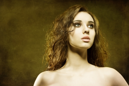 close-up portrait of pretty brunette woman with wavy and wet hair-style on grunge backgroundの写真素材