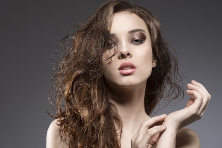 sensual brunette woman in close-up portrait with natural long wavy hair-style with sexy expressionの写真素材