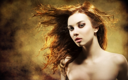 portrait of sensual young girl with brown wavy flying hair and pretty make-up with strong color and grunge backgroundの写真素材