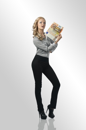 full-length portrait of business woman with blonde curly hair-style and elegant suit, taking money in the handの写真素材