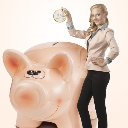 blonde pretty business woman saving big coin and wearing elegant suit  Smiling and looking in camera の写真素材