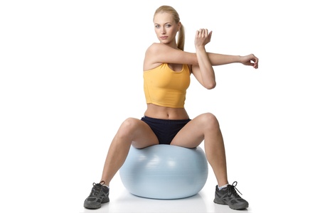 very cute blond girl in fitness pose sitting on big ball isolated on white. NATURAL SKINの写真素材
