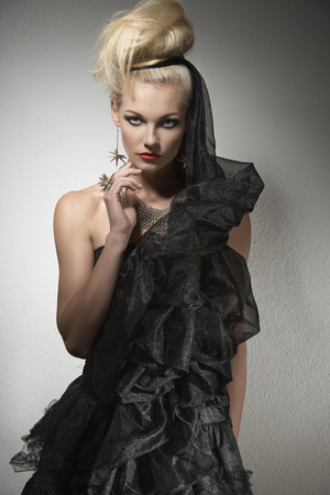 portrait of pretty blonde girl with creative Halloween dress, dark make-up, elegant hair-style and silver jewellery の写真素材