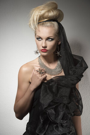 cute blonde female with dark glamour Halloween costume, bright accessories and creative make-up and hair-style の写真素材
