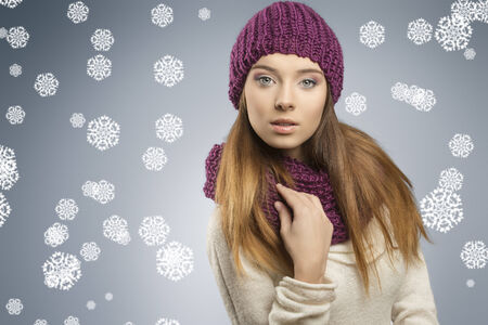 attractive young girl with fashion winter style and long smooth hair. She wearing wool purple hat, scarf and white sweater, looking in camera の写真素材