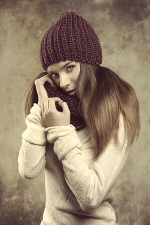 winter fashion shoot of a beauty young girl with long smooth hair, purple wool hat, scarf and warm white sweater  の写真素材