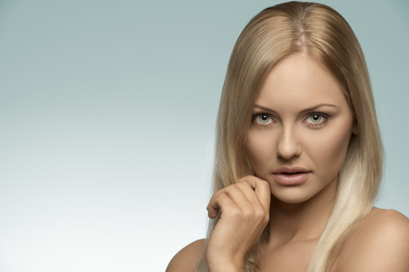 beauty close-up portrait of natural girl with blonde smooth hair, perfect skin and naked shoulder, looking in camera の写真素材
