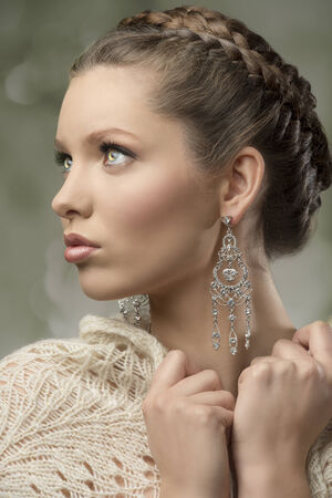 close-up portrait of charming woman with splendid eyes, elegant hair-style, precious earrings and wool shawl   の写真素材