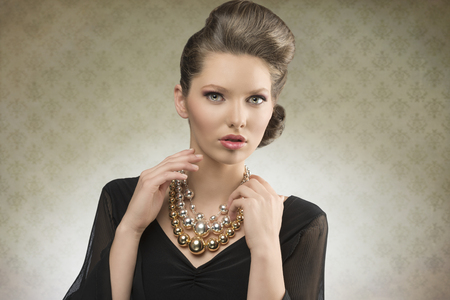 portrait of charming fashion lady posing with brown hair-style, elegant black dress and bright necklace   
の写真素材