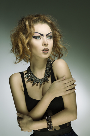 fashion portrait of modern dark punk lady with bizarre purple make-up, black sexy dress and studs accessories  の写真素材