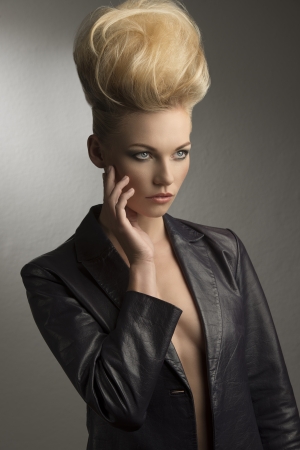portrait of pretty girl with fashion rock look posing with modern  creative hairdo and leather jacket の写真素材