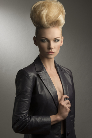 cool portrait of charming blonde girl with fashion rock style, creative hairdo and leather jacket の写真素材