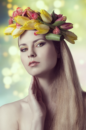close-up spring portrait of sexy blonde girl, with long smooth hair, floral garland and colorful make-up. Looking in camera   の写真素材