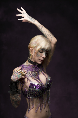 sexy adult woman posing with carnival style, glitter bra, tattoos and creative accessories の写真素材