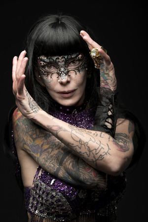 sensual carnival lady with brown smooth hair and tattoos wearing glitter bra, baroque mask and glitter bra の写真素材