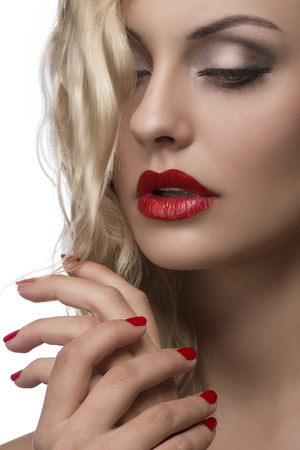 sexy young girl with red lips and nail polish, shiny wavy blonde hair の写真素材