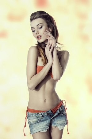 sensual woman with summer style posing with bikini, jeans shorts and long hair-style. の写真素材