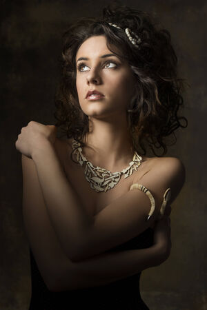 portrait of sensual brunette woman with curly hair-style, creative accessories looking upの写真素材