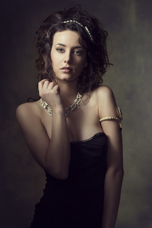 fashion portrait of very sensual brunette woman with curly hair-style, wearing creative jewels and sexy dress の写真素材