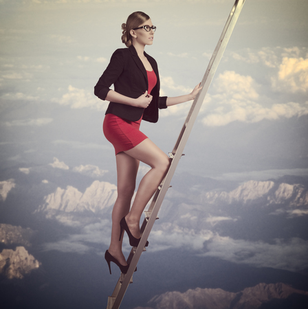 concept portrait of young business woman climbing staircase t the top  with elegant sexy suit の写真素材