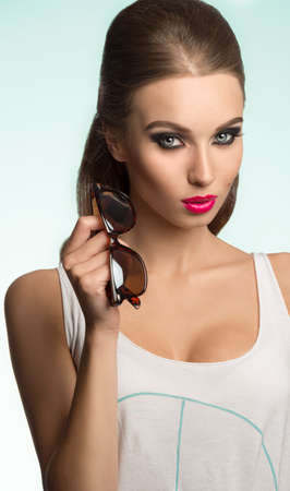 close-up shoot of sexy beautiful brunette girl with casual shirt, cool sunglasses and charming make-up の写真素材