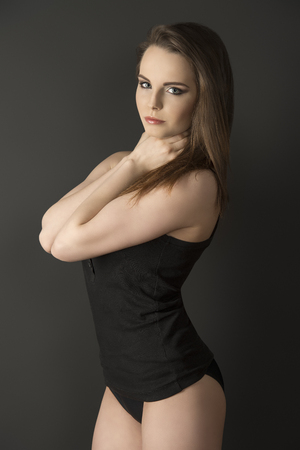 girl in sensual pose with long smooth hair wearing black comfortable underwear, singlet and sexy panties の写真素材