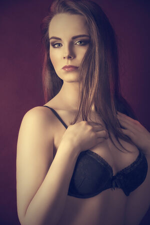 Beautiful, young, sensual woman with long, straight, brown hair, dark make up, wearing sexy, balck lingerie.の写真素材