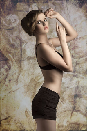 sensual young girl wearing black bra and shorts, in fashion pose with elegant hair-style and stylish make-up の写真素材