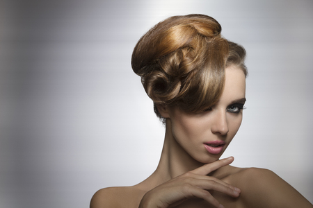 beauty portrait of sexy girl with charming expression posing with fashion elegant hair-style and stylish make-up の写真素材