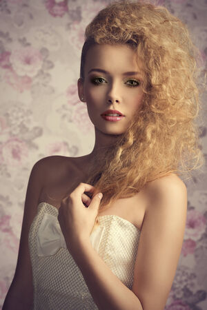 beautiful young blonde lady posing in close-up fashion shoot with creative stylish hair-style, colorful make-up and elegant white dressの写真素材
