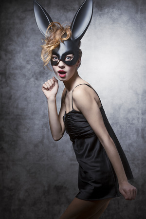 Sexy, charming, elegant, lovely woman in carnival dress and bunny mask. She has got curly wild hair and nice makeup.の写真素材