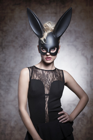 Sexy, pretty, elegant blonde woaman in carnival rabbit mask, balck dress and make up.の写真素材